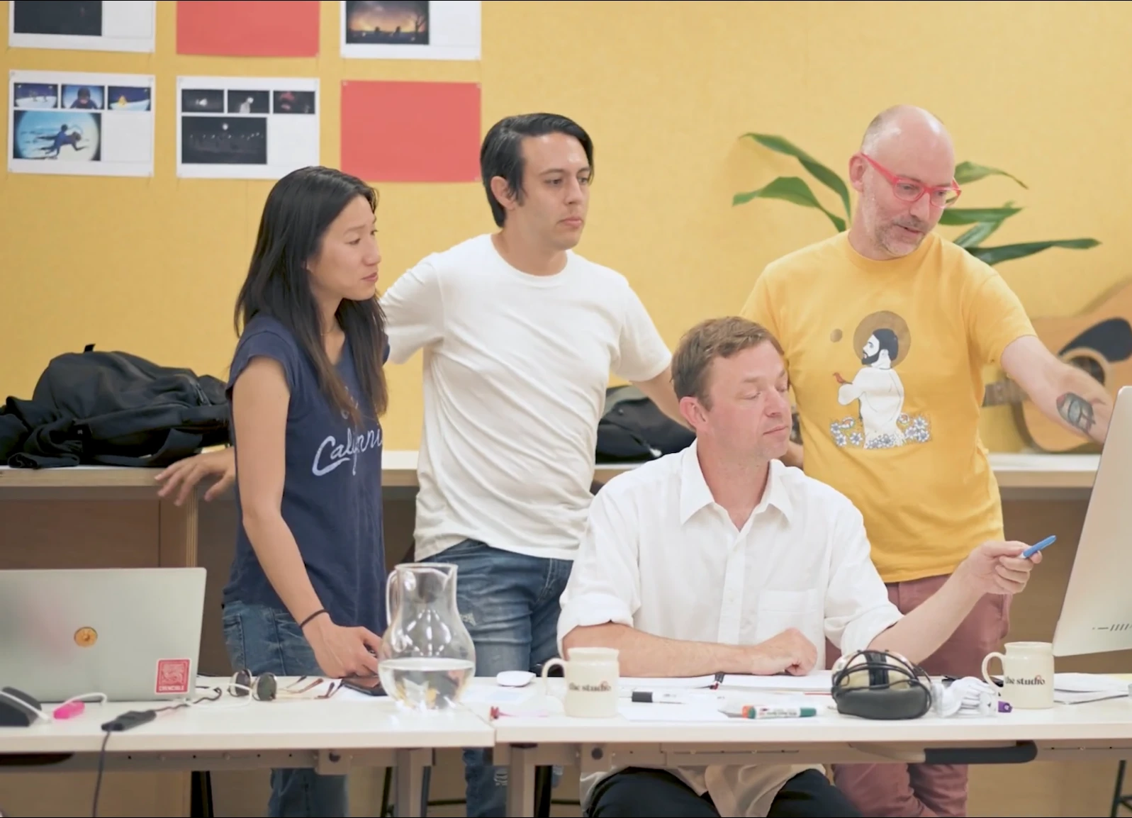 Cross-disciplinary workshop team reviewing material on a computer