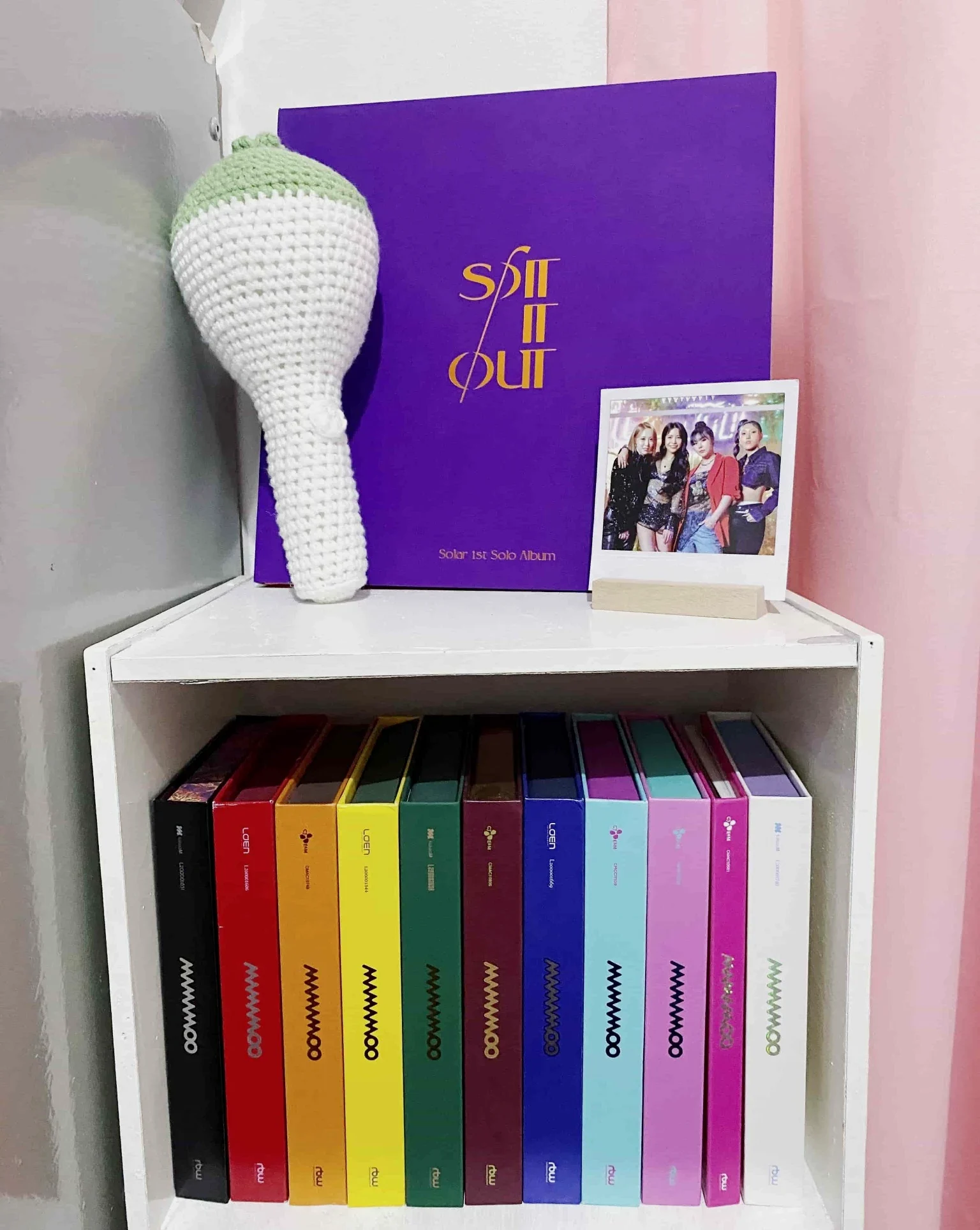 K-pop fan shelf with organized Mamamoo albums, lightstick, and framed photo
